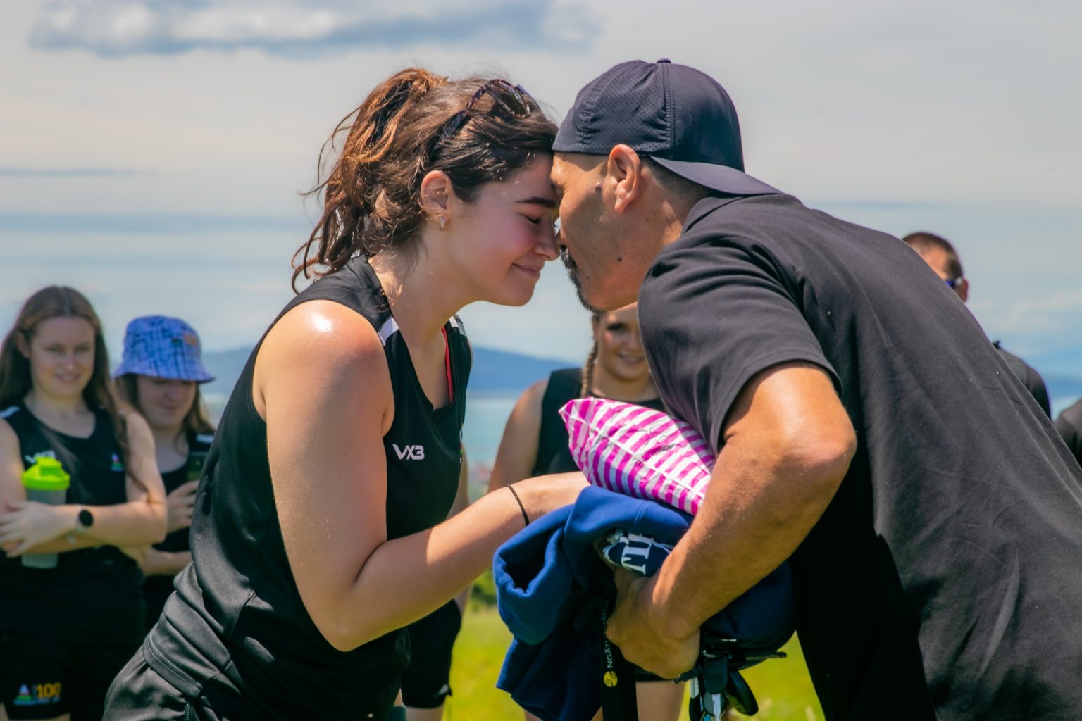 Image of man and women (both dressed in black), performing the 'Hongi'.