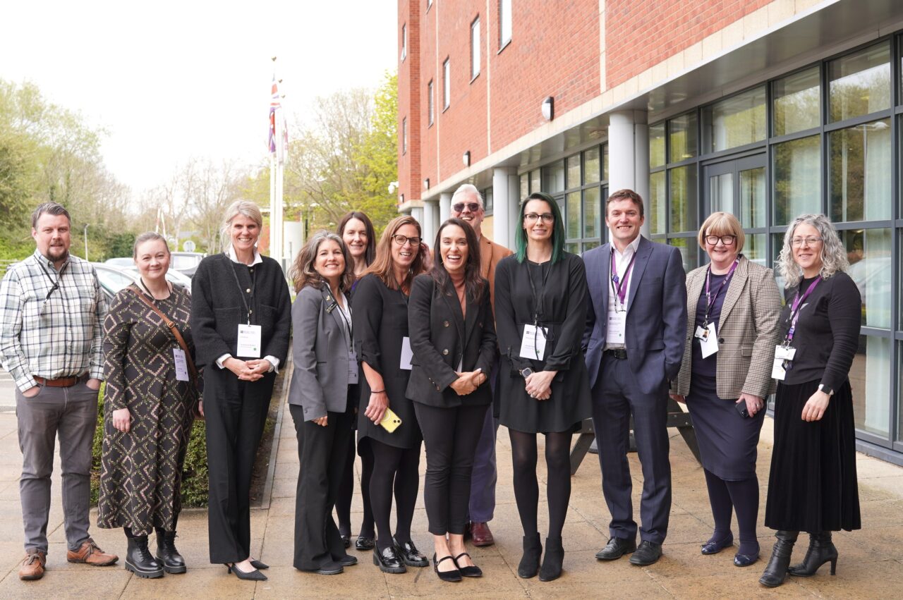 Group photo of smartly dressed people standing outside a building